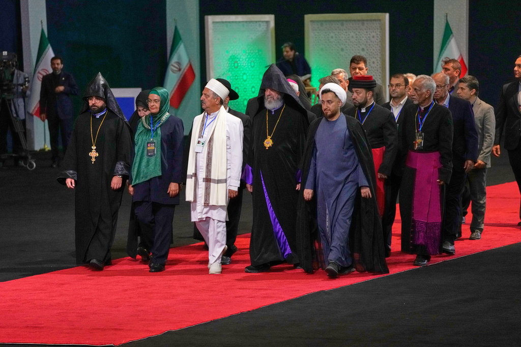 Iranian religious leaders and other mourners walk past the coffins of the late Iranian Supreme Leader Ayatollah Ali Khamenei and members of his family during a viewing ceremony ahead of the dayslong funeral ceremonies at the Imam Khomeini Mosalla Grand Mosque in Tehran, Iran, Friday, July 3, 2026. (AP Photo/Vahid Salemi) CORRECTION : The religious leaders are Iranian, not foreigners