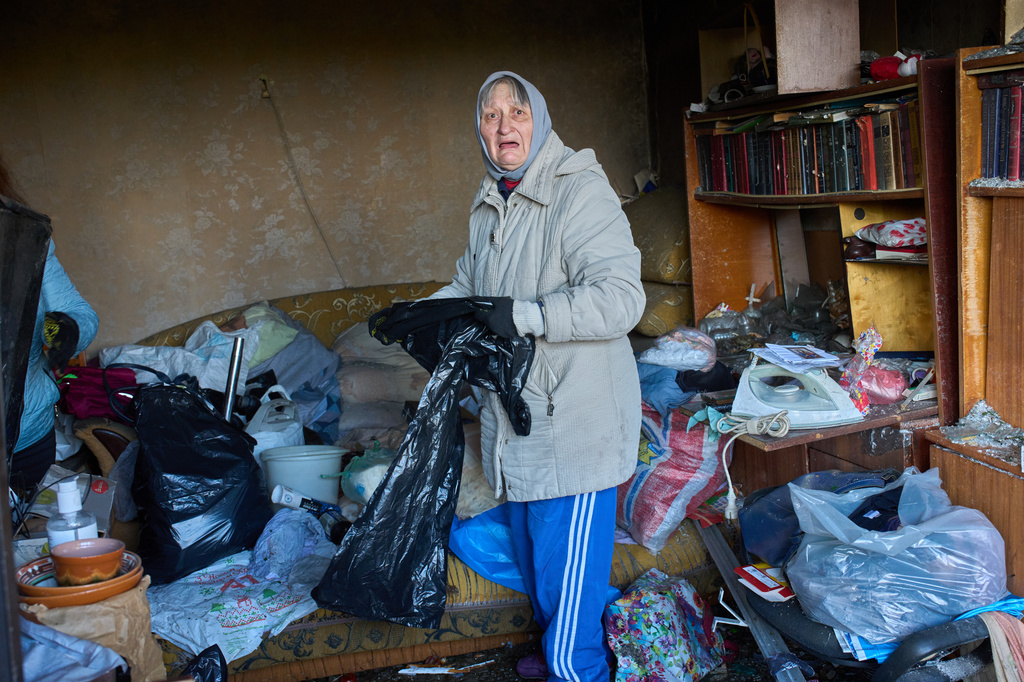 An elderly woman cleans up the mess in her damaged apartment after a missile strike during Russia's night air attack in Kyiv, Ukraine, Wednesday, Oct. 14, 2026. (AP Photo/Efrem Lukatsky)