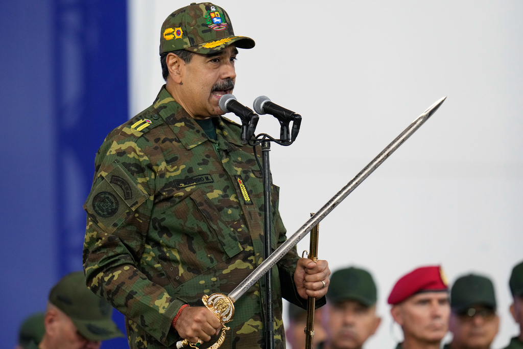 Venezuelan President Nicolas Maduro holds a ceremonial sword said to have belonged to independence hero Simon Bolivar during a government-organized civic-military march in Caracas, Venezuela, Tuesday, Nov. 25, 2025. (AP Photo/Ariana Cubillos)