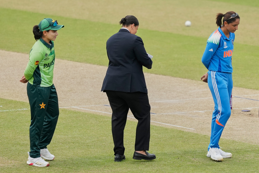 India's captain Harmanpreet Kaur, right, and Pakistan's captain Fatima Sana proceed for coin toss before the ICC Women's Cricket World Cup match between India and Pakistan at Premadasa Stadium in Colombo, Sri Lanka, Sunday, Oct, 5, 2025. (AP Photo/Eranga Jayawardena)