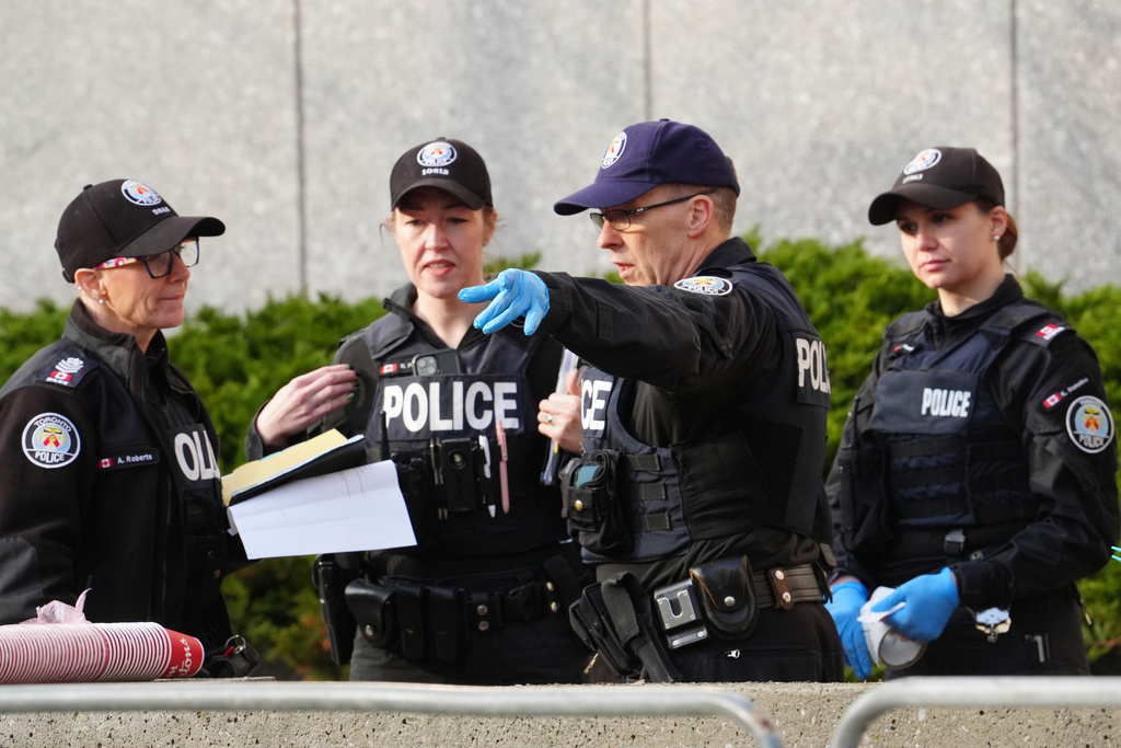 Toronto police investigate the scene after the U.S. consulate was hit by gunfire in Toronto on Tuesday March 10, 2026. (Frank Gunn/The Canadian Press via AP)