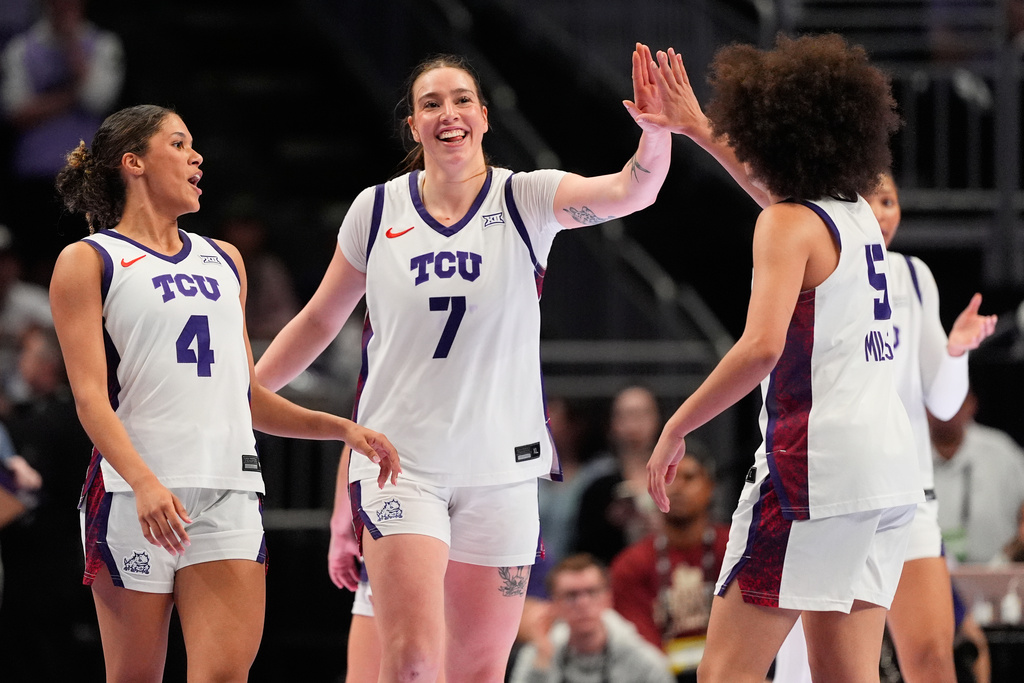 TCU's Donovyn Hunter (4), Marta Suarez (7) and Olivia Miles (5) celebrate after a basket during second half of an NCAA college basketball game against Kansas State, in the semifinals of the Big 12 Conference tournament Saturday, March 7, 2026, in Kansas City, Mo. (AP Photo/Charlie Riedel)