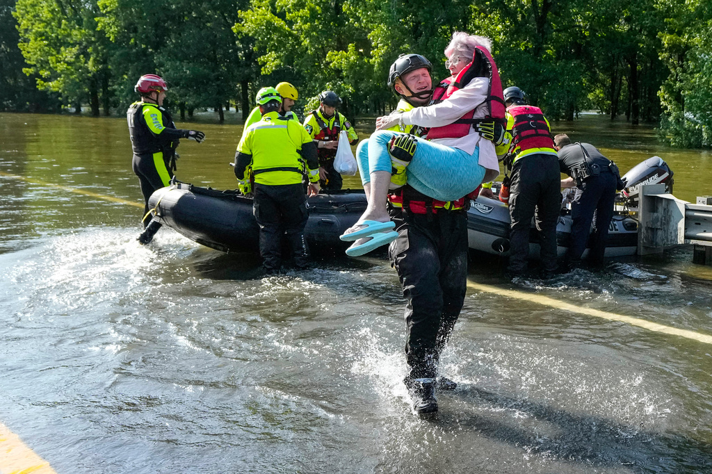 FILE - Conroe firefighter Cody Leroy carries a resident evacuated in a boat by the CFD Rapid Intervention Team from her flooded home in the aftermath of a severe storm May 2, 2024, in Conroe, Texas. (Brett Coomer/Houston Chronicle via AP)
