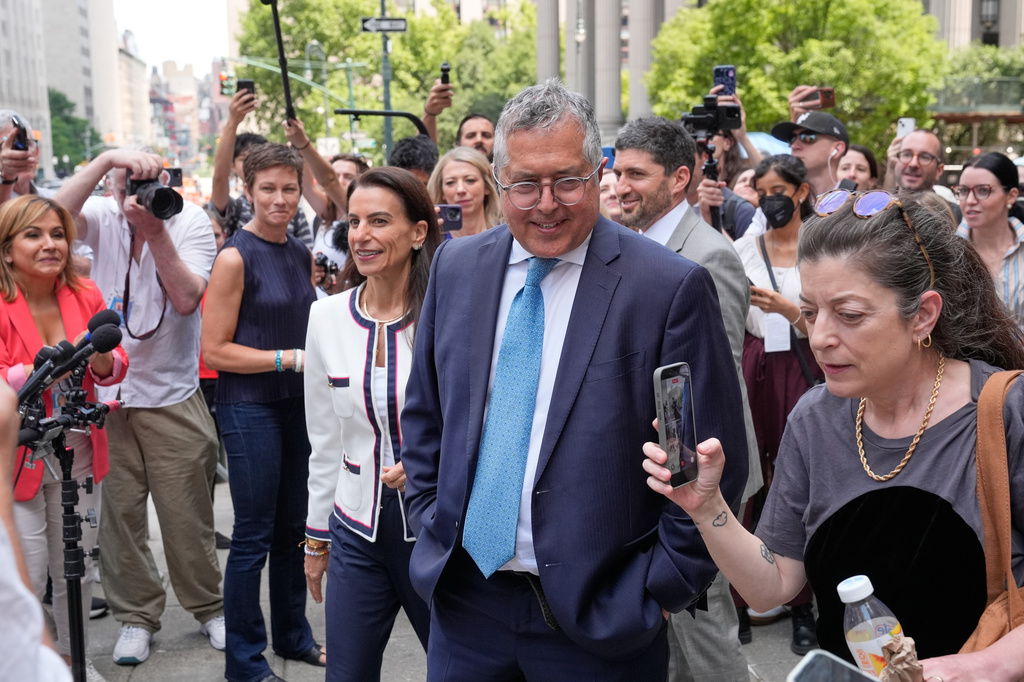 Marc Agnifilo, center right, and Karen Friedman Agnifilo, center left, lawyers for Luigi Mangione, are surrounded by media as they leave a federal courthouse in New York, Monday, June 29, 2026. (AP Photo/Seth Wenig)