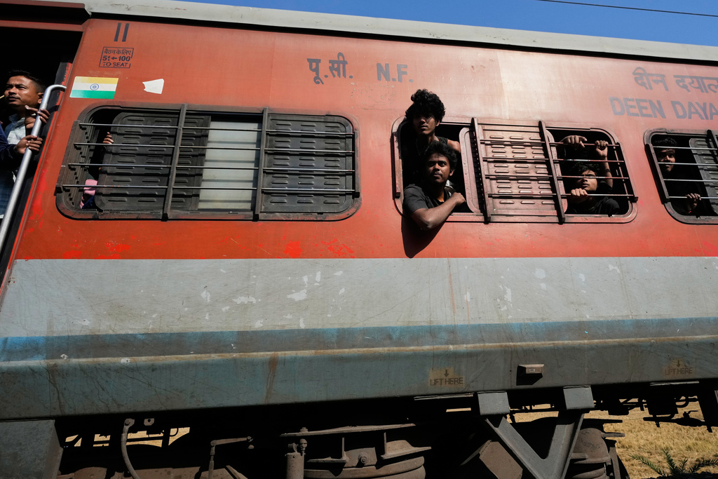 Passengers from a train look at a carcass of an Asiatic wild elephant (unseen) being removed from a railway track after a speeding train hit a heard of wild elephant in the early morning in Changjurai village east of Guwahati, India, Saturday, Dec. 20, 2025. (AP Photo/Anupam Nath)