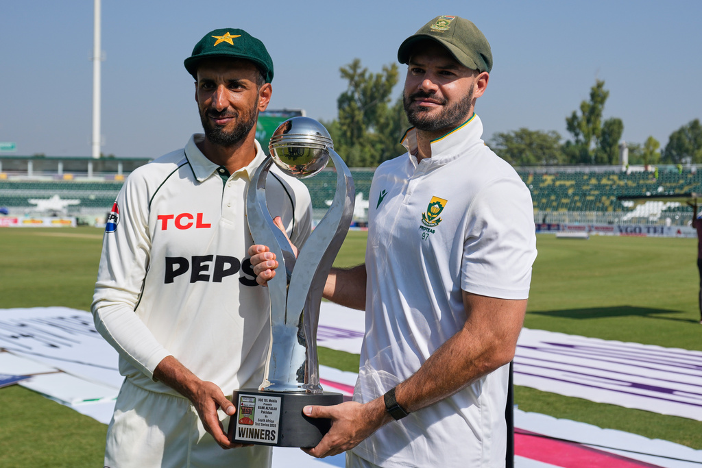 CORRECTS PAKISTANI PLAYER'S NAME - Pakistan's Shan Masood, left, and South Africa's Aiden Markram pose for a photograph with test series trophy on the end of the second test cricket match between Pakistan and South Africa, in Rawalpindi, Pakistan, Thursday, Oct. 23, 2025. (AP Photo/Anjum Naveed)