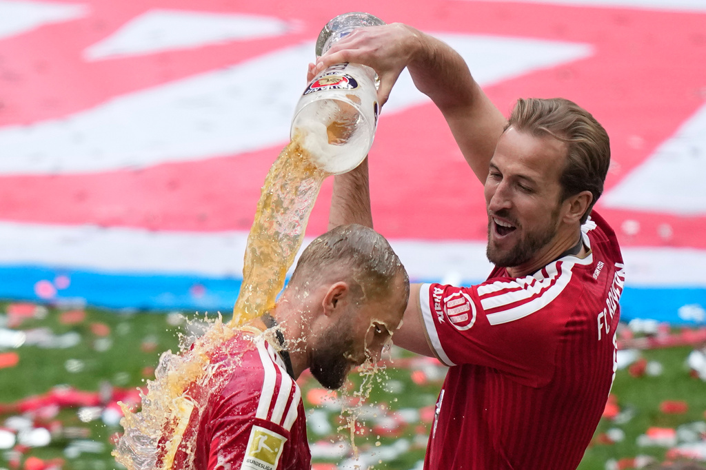 Bayern's Harry Kane, pours beer on Bayern's Joshua Kimmich as they celebrate the Bundesliga title at the end of the soccer match between Bayern and FC Cologne in Munich, Germany, Saturday, May 16, 2026. (AP Photo/Matthias Schrader)