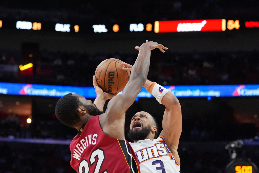 Phoenix Suns guard/forward Dillon Brooks (3) reacts as he is fouled by Miami Heat forward Andrew Wiggins (22) during the first half of an NBA basketball game, Tuesday, Jan. 13, 2026, in Miami. (AP Photo/Rebecca Blackwell)