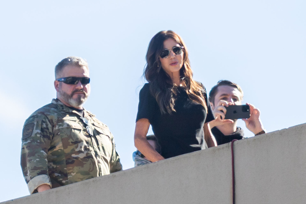 U.S. Secretary of Homeland Security Kristi Noem, center, stands on the roof of a U.S. Immigration and Customs Enforcement facility in Portland, Ore., Tuesday, Oct. 7, 2025. (AP Photo/Ethan Swope)