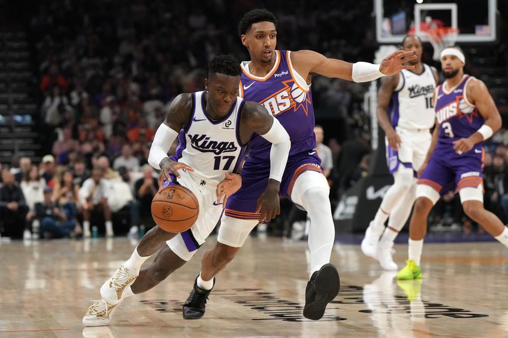 Sacramento Kings guard Dennis Schroder (17) drives past Phoenix Suns guard Ryan Dunn during the first half of an NBA basketball game, Wednesday, Oct. 22, 2025, in Phoenix. (AP Photo/Rick Scuteri)