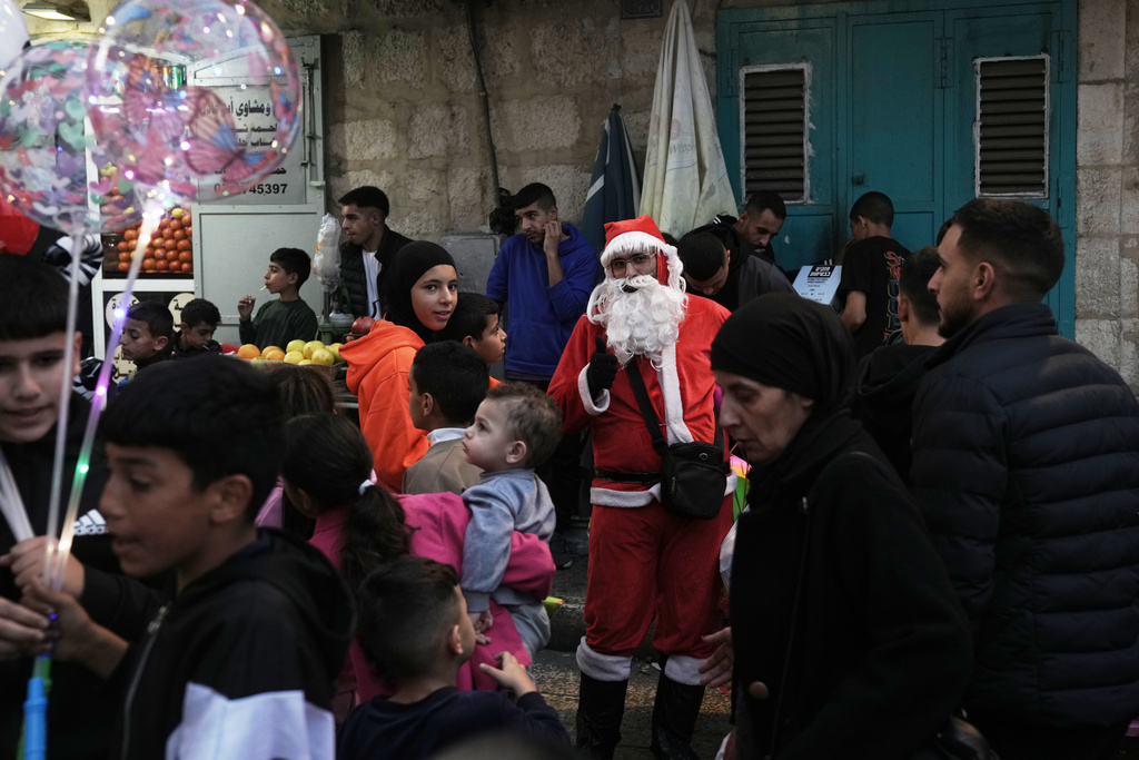 Palestinians take part in a Christmas tree–lighting event in Manger Square, next to the Church of the Nativity, traditionally regarded as the birthplace of Jesus Christ ahead of Christmas in the West Bank city of Bethlehem Saturday, Dec. 6, 2025. (AP Photo/Mahmoud Illean)