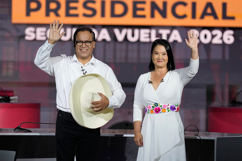 Presidential candidate Keiko Fujimori of the Popular Force party and her rival Roberto Sanchez of Together for Peru party wave during a presidential debate, in Lima, Peru, Sunday, May 31, 2026. (AP Photo/Martin Mejia)