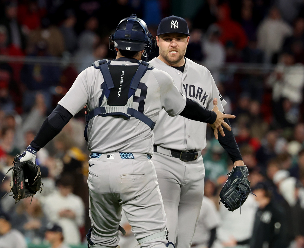 New York Yankees catcher Austin Wells, left, and pitcher David Bednar, right, celebrate their win over the Boston Red Sox at the end of a baseball game, Thursday, April 23, 2026, in Boston. (AP Photo/Mark Stockwell)