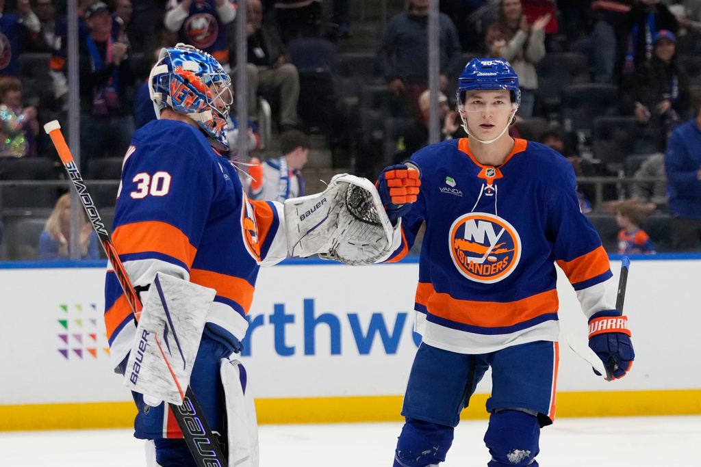 New York Islanders' Matthew Schaefer (48) celebrates with goaltender Ilya Sorokin (30) after scoring his first NHL goal during the third period of an NHL hockey game against the Washington Capitals Saturday, Oct. 11, 2025, in Elmont, N.Y. (AP Photo/Frank Franklin II)
