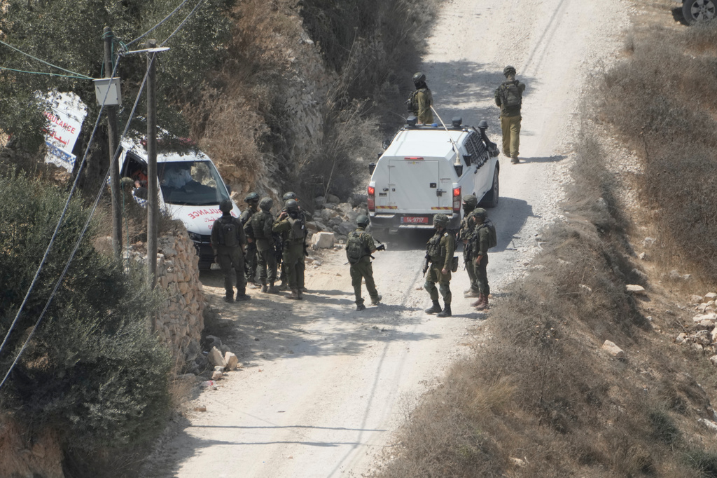 Israeli soldiers secure a building under construction as ambulances evacuate injured Palestinians following an attack by Israeli settlers in the occupied West Bank village of Qusra, Saturday, Aug. 29, 2026. (AP Photo/Majdi Mohammed)