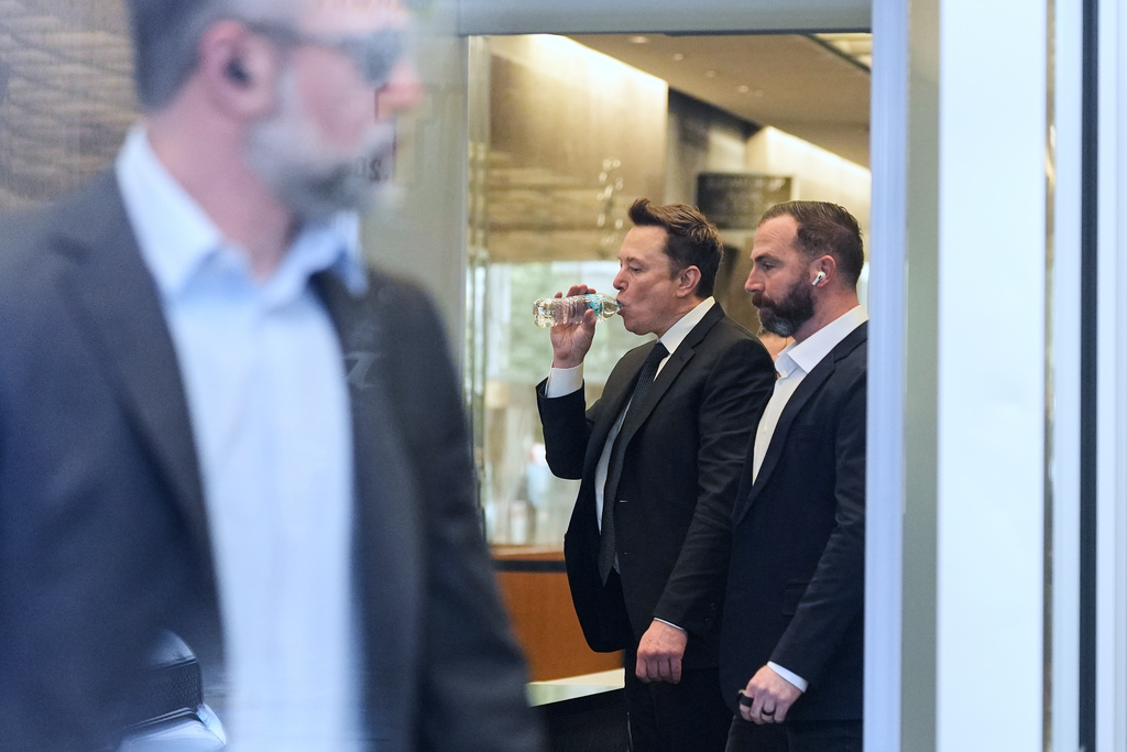 Elon Musk, center, arrives for a Twitter shareholder trial at the U.S. District Court for the Northern District of California, Wednesday, March 4, 2026, in San Francisco. (AP Photo/Godofredo A. Vásquez)