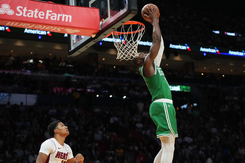 Boston Celtics guard Jaylen Brown, right, dunks over Miami Heat guard Dru Smith, left, during the first half of an NBA basketball game, Wednesday, April 1, 2026, in Miami. (AP Photo/Lynne Sladky)
