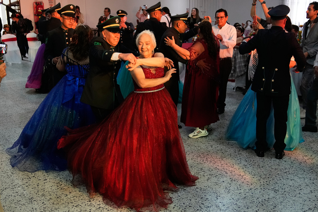 Mariela Diaz, 73, dances a waltz during a quinceanera celebration for women who never had a traditional 15th birthday party, organized by the Suenos Hechos foundation in Bogota, Colombia, Friday, Oct. 24, 2025. (AP Photo/Fernando Vergara)