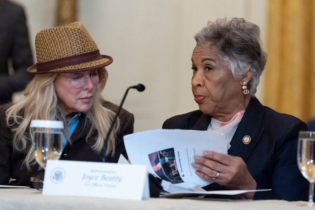 Mindy Levine, left, listens as Rep. Joyce Beatty, D-Ohio, talks before President Donald Trump arrives for a board meeting of the John F. Kennedy Memorial Center For The Performing Arts in the East Room of the White House, Monday, March 16, 2026, in Washington. (AP Photo/Alex Brandon)