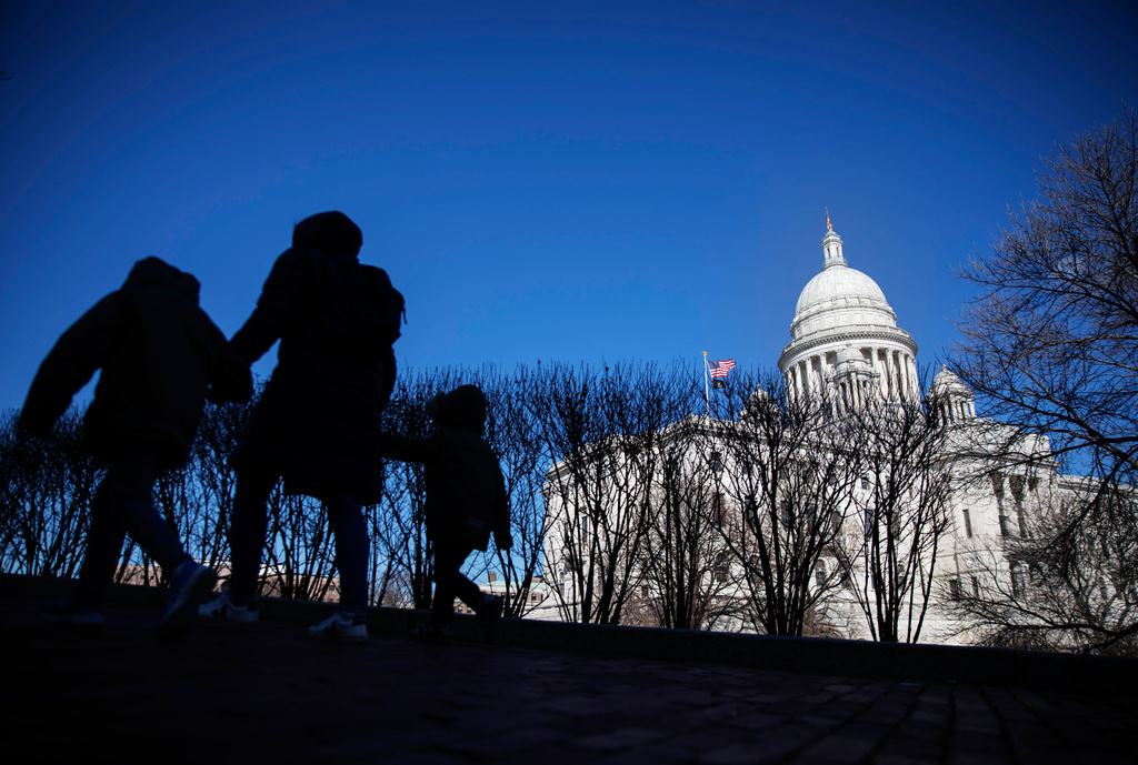FILE - Pedestrians walk past the Rhode Island Statehouse, March 1, 2020, in Providence, R.I. (AP Photo/David Goldman, File)