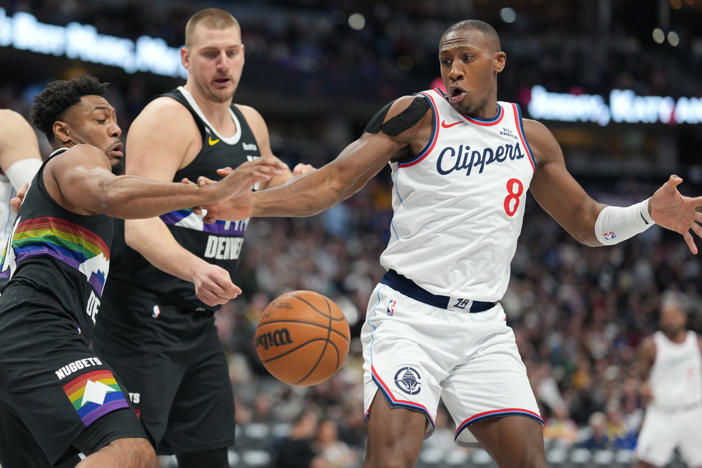 From left to right, Denver Nuggets guard Jalen Pickett and center Nikola Jokić pursue the ball with Los Angeles Clippers guard Kris Dunn in the second half of an NBA basketball game Friday, Jan. 30, 2026, in Denver. (AP Photo/David Zalubowski)