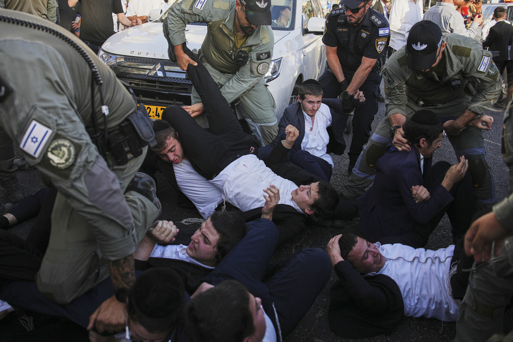 Police disperse Ultra-Orthodox Jews blocking a highway during a protest against army recruitment, in Bnei Brak, Israel, Tuesday, Aug. 19, 2025. (AP Photo/Ohad Zwigenberg)