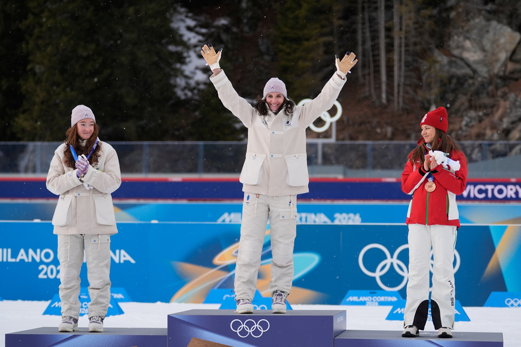 Silver medalist Lou Jeanmonnot, of France, from left, gold medalist Julia Simon, of France, and bronze medalist Lora Hristova, of Bulgaria, celebrate after the women's 15-kilometer individual biathlon race at the 2026 Winter Olympics in Anterselva, Italy, Wednesday, Feb. 11, 2026. (AP Photo/Andrew Medichini)
