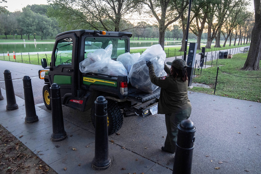 A National Park Service employee loads a utility vehicle with bags of trash along the National Mall on Wednesday, Oct. 1, 2025, in Washington. (AP Photo/Mark Schiefelbein)