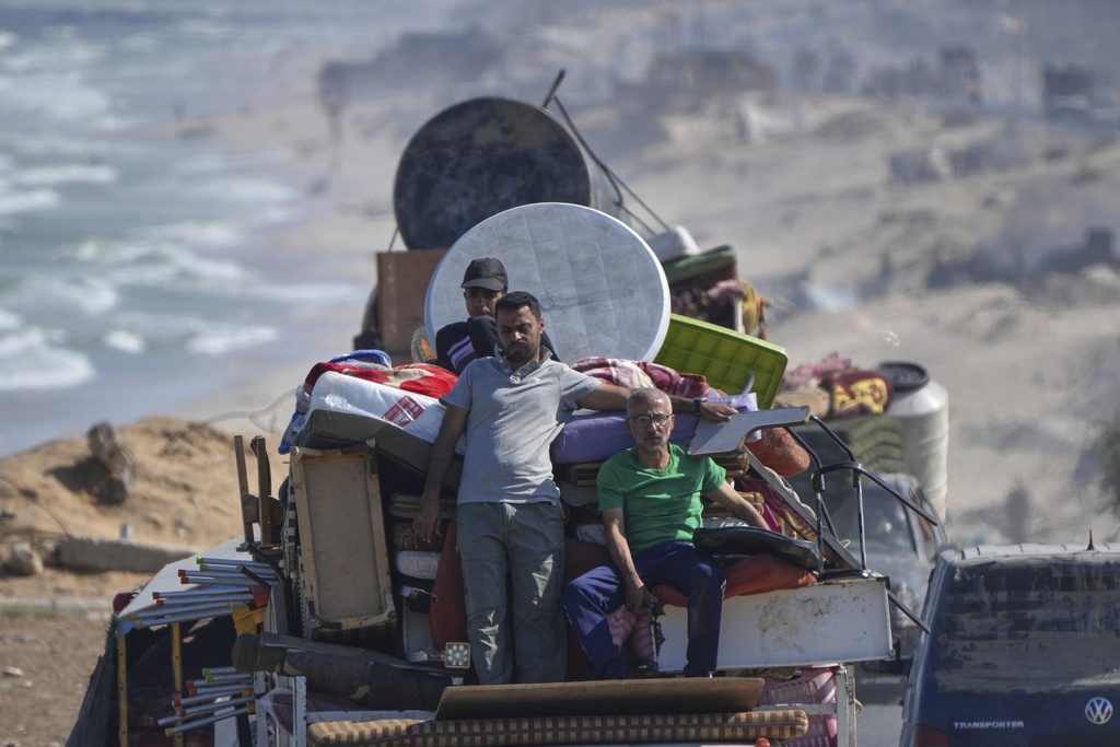 Displaced Palestinians fleeing northern Gaza carry their belongings along the coastal road toward southern Gaza, Tuesday, Sept. 9, 2025, after the Israeli army issued evacuation orders from Gaza City. (AP Photo/Jehad Alshrafi)