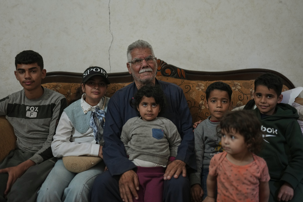Palestinian Yusuf Abu Hamam, center, who was expelled from his town during the first Israeli-Arab war in 1948, poses for a photo with his grandchildren at his home in the Shati refugee camp in Gaza City, Wednesday, May 13, 2026. (AP Photo/Jehad Alshrafi)