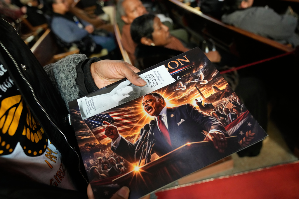A person holds a calendar with a photo of the Rev. Jesse Jackson during the public visitation at Rainbow PUSH Coalition headquarters in Chicago, Friday, Feb. 27, 2026. (AP Photo/Nam Y. Huh)