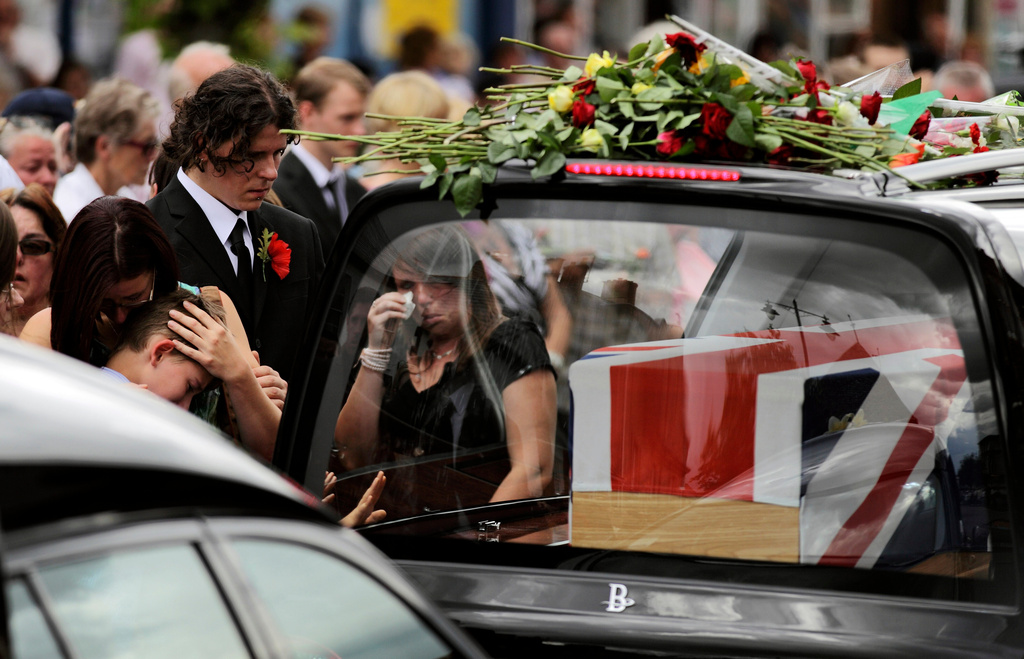 FILE - Mourners react as funeral hearses drive the coffins of four British soldiers through the town of Wootton Bassett in England, Thursday, July 22, 2010, after their bodies were repatriated to the UK after they were killed in Afghanistan. (AP Photo/Matt Dunham, file)