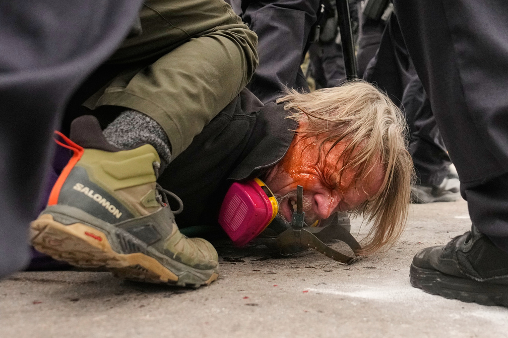 A man is pushed to the ground as federal immigration officers confront protesters outside Bishop Henry Whipple Federal Building, Thursday, Jan. 15, 2026, in Minneapolis. (AP Photo/John Locher)