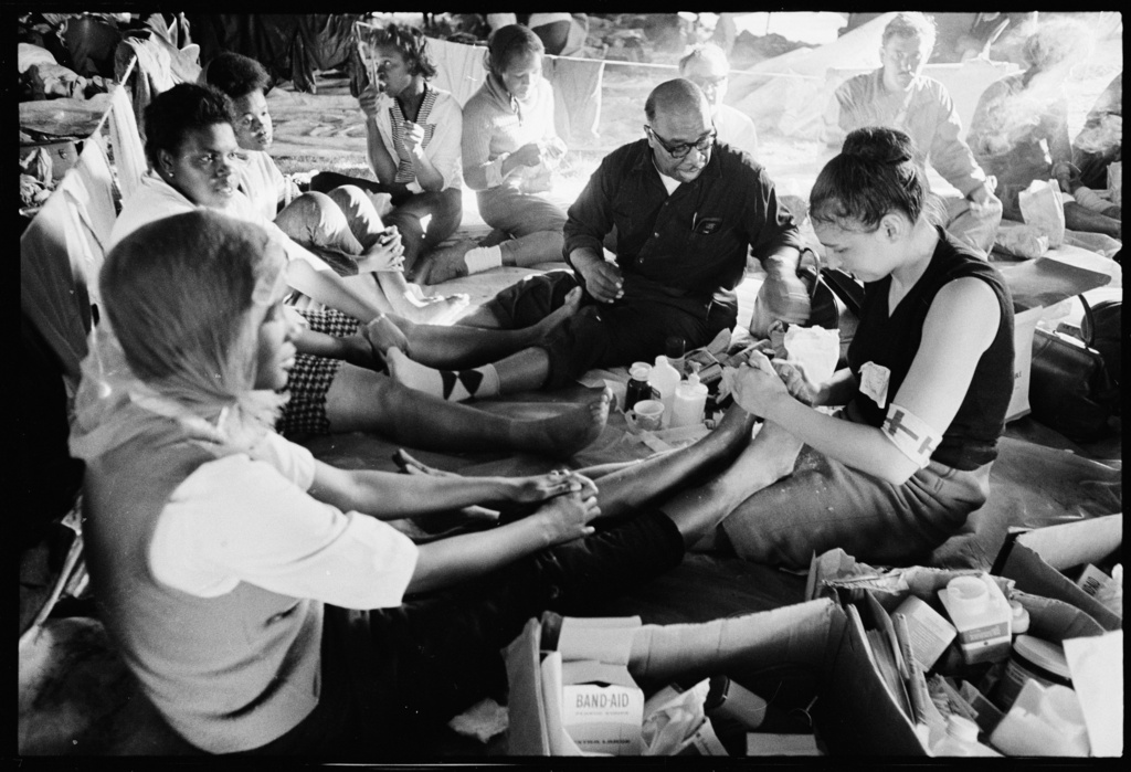 This photo taken by Civil Rights photographer Matt Herron shows Doris Wilson, 20, a resident of Marion, Alabama, getting medical care from Dr. June Finer, one of many volunteer doctors who escorted marchers along their 54-mile journey. Highway 80, Ala., March 1965. (Matt Herron/Jeannine Herron and Stanford University Libraries via AP)
