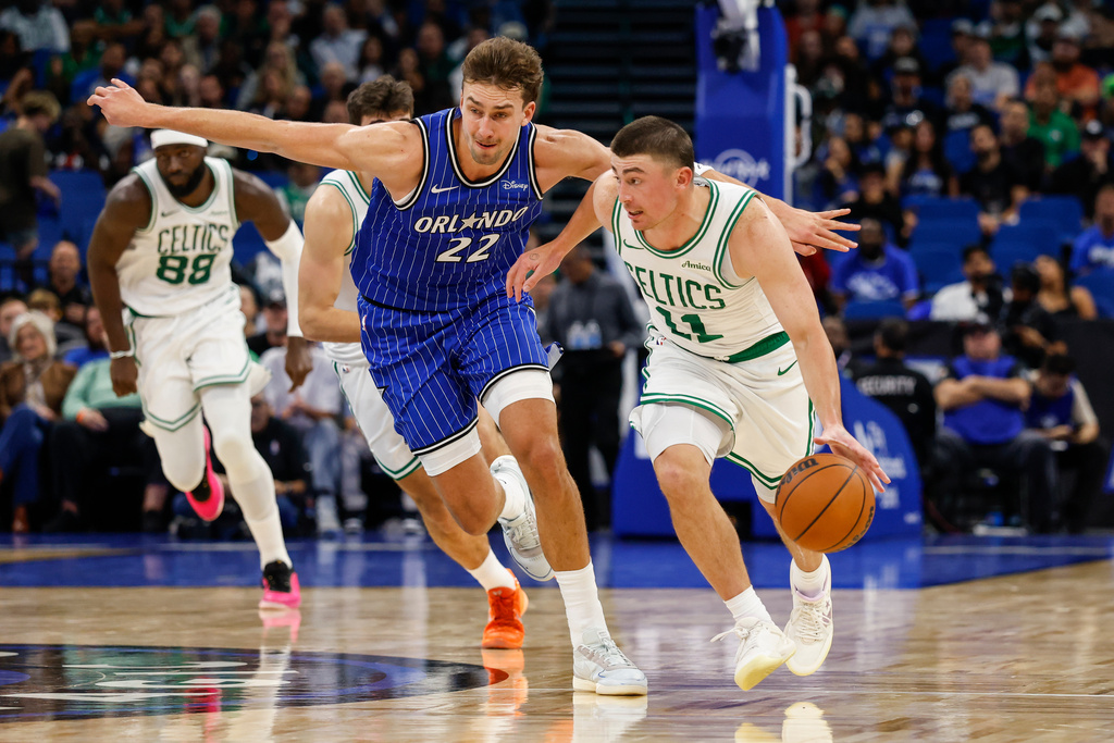 Boston Celtics guard Payton Pritchard (11) brings the ball down court as he is defended by Orlando Magic forward Franz Wagner (22) during the first half of an NBA basketball game, Sunday, Nov. 9, 2025, in Orlando, Fla. (AP Photo/Kevin Kolczynski)
