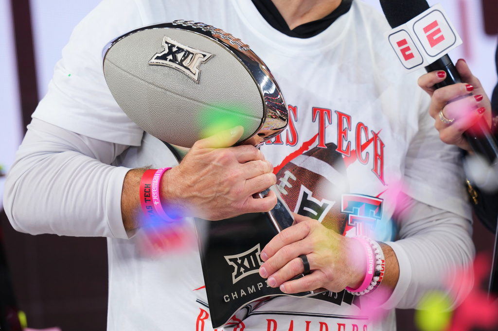 FILE - Texas Tech head coach Joey McGuire holds the trophy after his team's win against BYU in the Big 12 Conference championship NCAA college football game on Dec. 6, 2025, in Arlington, Texas. (AP Photo/Julio Cortez, File)