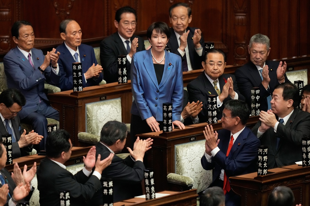 FILE - Lawmakers applaud as Sanae Takaichi, center, is elected as Japan's new prime minister during the extraordinary session of the lower house in Tokyo, Oct. 21, 2025. (AP Photo/Eugene Hoshiko, File)