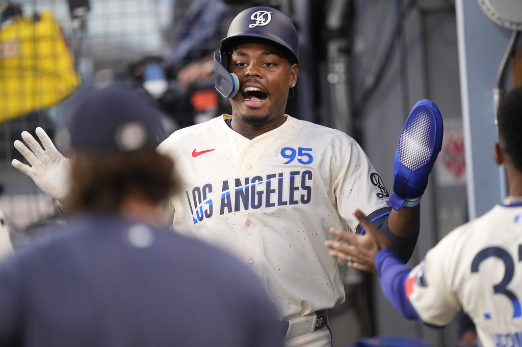 Los Angeles Dodgers' Josue De Paula is congratulated by teammates in the dugout after scoring on a single by Mookie Betts during the second inning of a baseball game against the San Francisco Giants, Saturday, Sept. 19, 2026, in Los Angeles. (AP Photo/Mark J. Terrill)