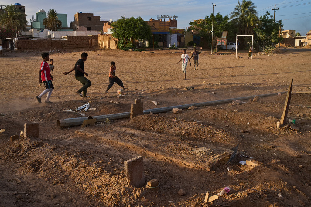 Children play soccer in a public park next to an improvised graveyard from the war in Omdurman, on the outskirts of Khartoum, Sudan, Thursday, April 23, 2026. (AP Photo/Bernat Armangue)