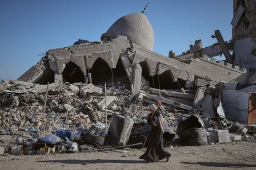 A Palestinian woman carrying her child walks past a destroyed mosque in Gaza City Sunday, Oct. 26, 2025. (AP Photo/Jehad Alshrafi) A Palestinian woman carrying her child walks past a destroyed mosque in Gaza City Sunday, Oct. 26, 2025. (AP Photo/Jehad Alshrafi)