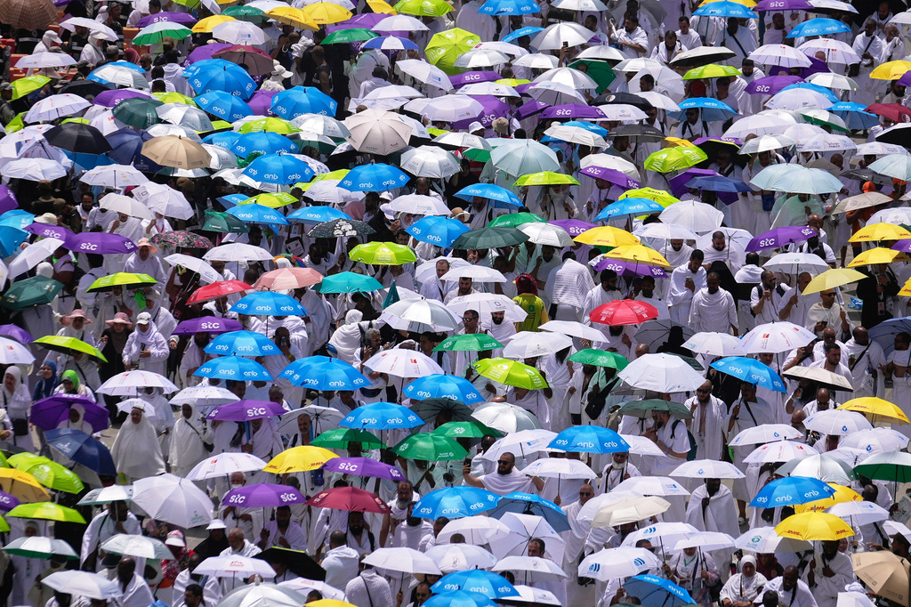 Muslim pilgrims hold umbrellas as they leave after offering noon prayers at Namirah mosque during the annual Hajj pilgrimage on the Plain of Arafat, near the holy city of Mecca, Saudi Arabia, Tuesday, May 26, 2026. (AP Photo/Altaf Qadri)