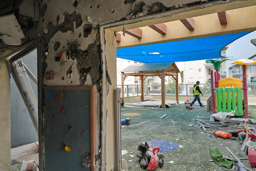 A man walks in the patio of a kindergarten hit by fragments of an Iranian missile in Rishon LeZion, Israel, Saturday, March 21, 2026. (AP Photo/Maya Levin)