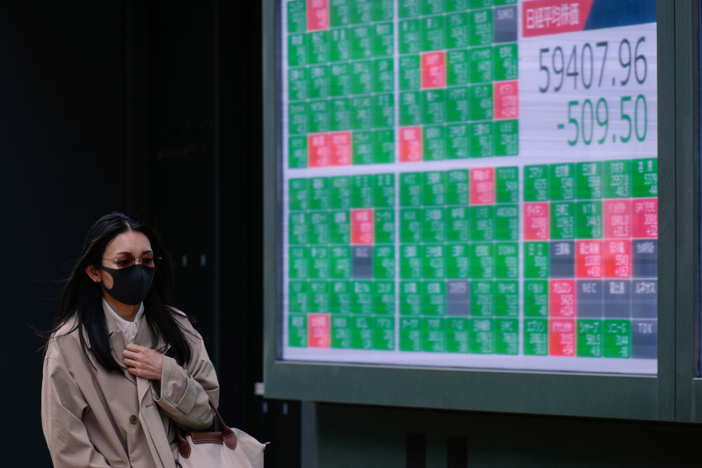 A person walks in front of an electronic stock board showing Japan's Nikkei index at a securities firm Thursday, April 30, 2026, in Tokyo. (AP Photo/Eugene Hoshiko)