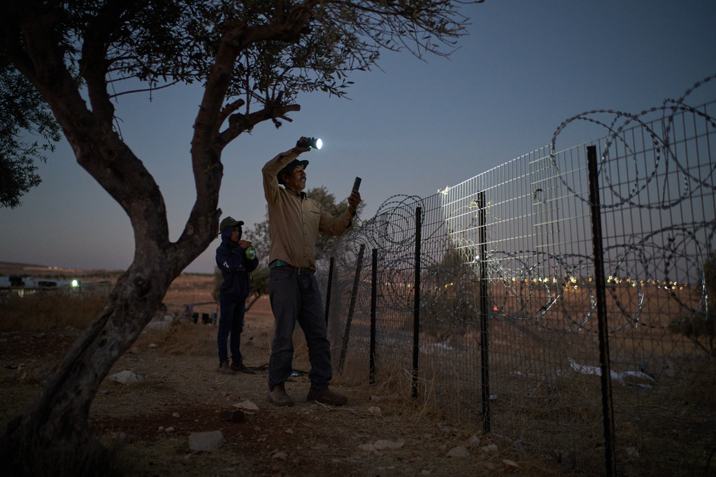 Nayef uses a flashlight after spotting Israeli settlers outside his Palestinian-Bedouin family's house on the outskirts of the West Bank town of Taybeh, Thursday, Sept. 10, 2026. (AP Photo/Leo Correa)