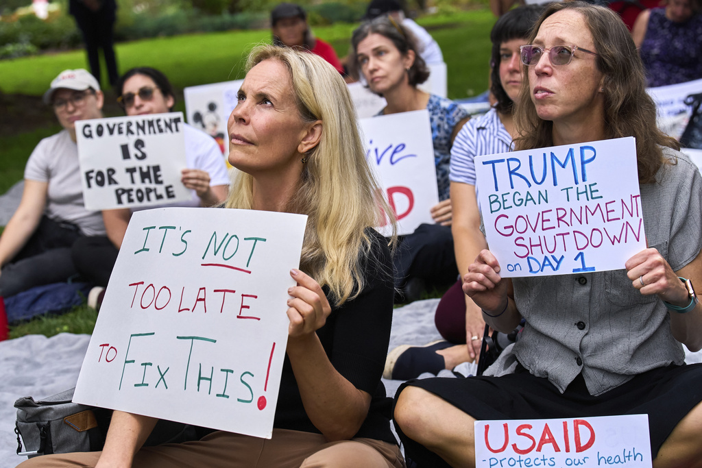 Layne Morrison, left, of Washington, and Courtney Creek, of Silver Spring, Md., who were let go from their jobs with the Education Department and a USAID funded grant respectively, hold signs about the looming government shutdown, Tuesday, Sept. 30, 2025, on Capitol Hill in Washington, during a rally with former federal employees. (AP Photo/Jacquelyn Martin)