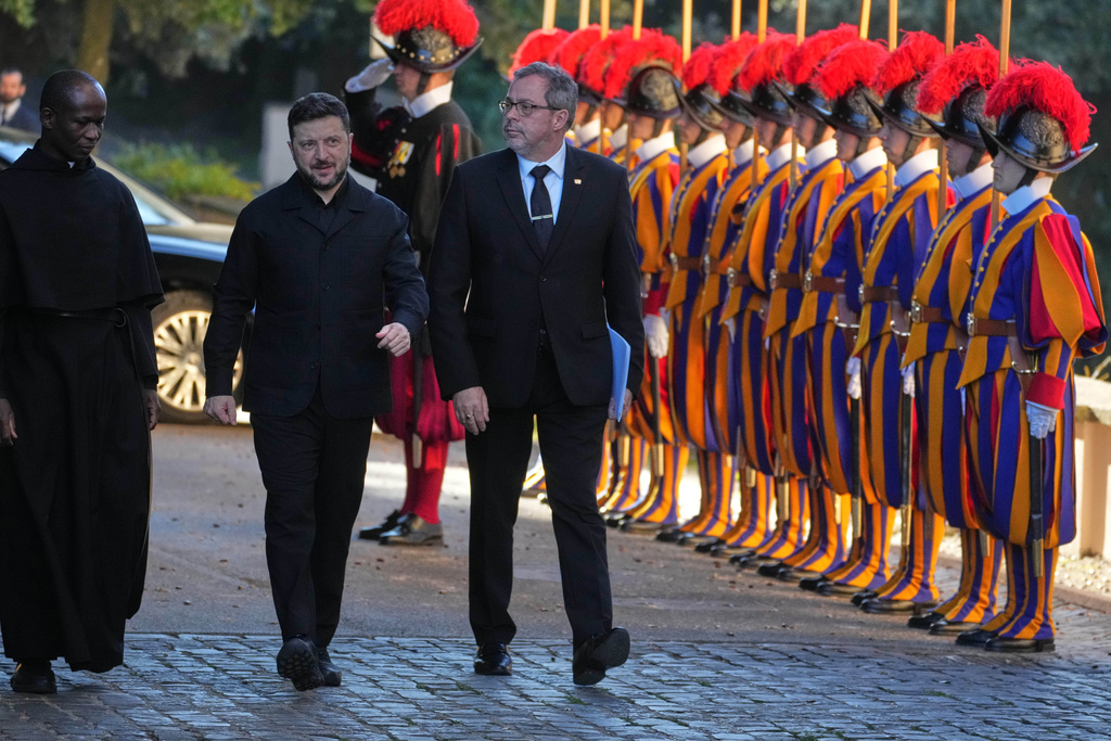 Ukraine President Volodymyr Zelenskyy, center, walks past Swiss guards as he arrives to meet with Pope Leo XIV in Castel Gandolfo, Italy, Tuesday, Dec. 9, 2025. (AP Photo/Andrew Medichini)