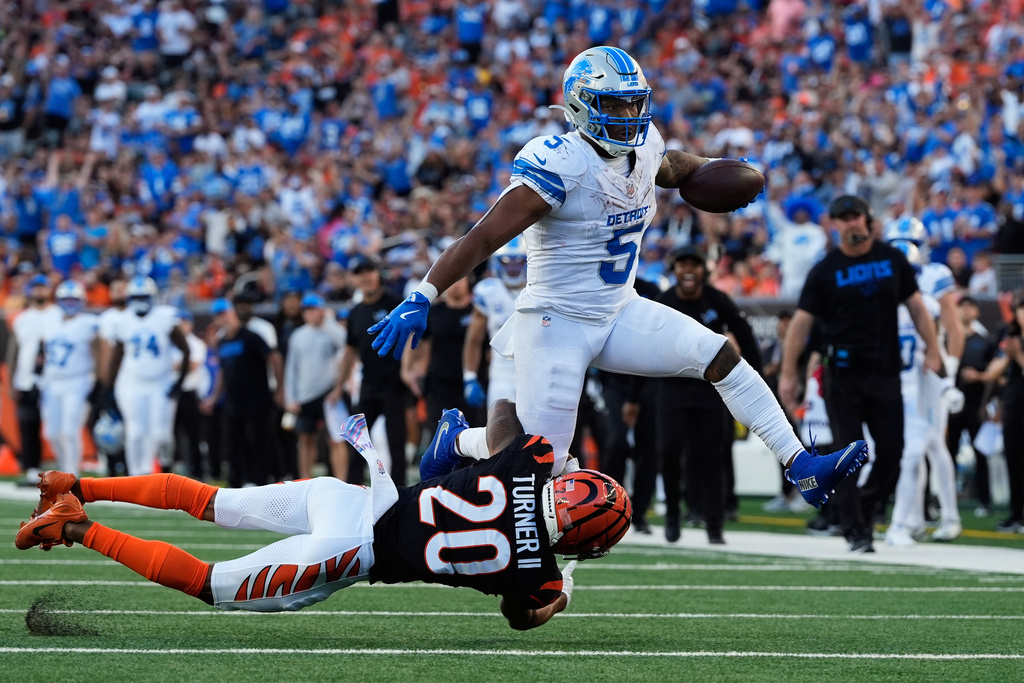 Detroit Lions running back David Montgomery (5) runs the ball as Cincinnati Bengals cornerback DJ Turner II (20) defends during the second half of an NFL football game Sunday, Oct. 5, 2025, in Cincinnati. (AP Photo/Carolyn Kaster)