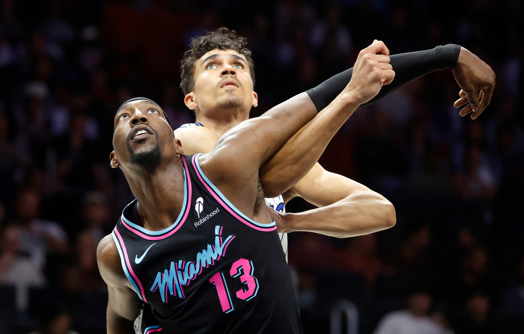 Miami Heat center Bam Adebayo (13) and Orlando Magic forward Tristan da Silva, right, wait for a rebound during the first half of an NBA basketball game in Miami, Saturday, March 14, 2026. (AP Photo/Rhona Wise)