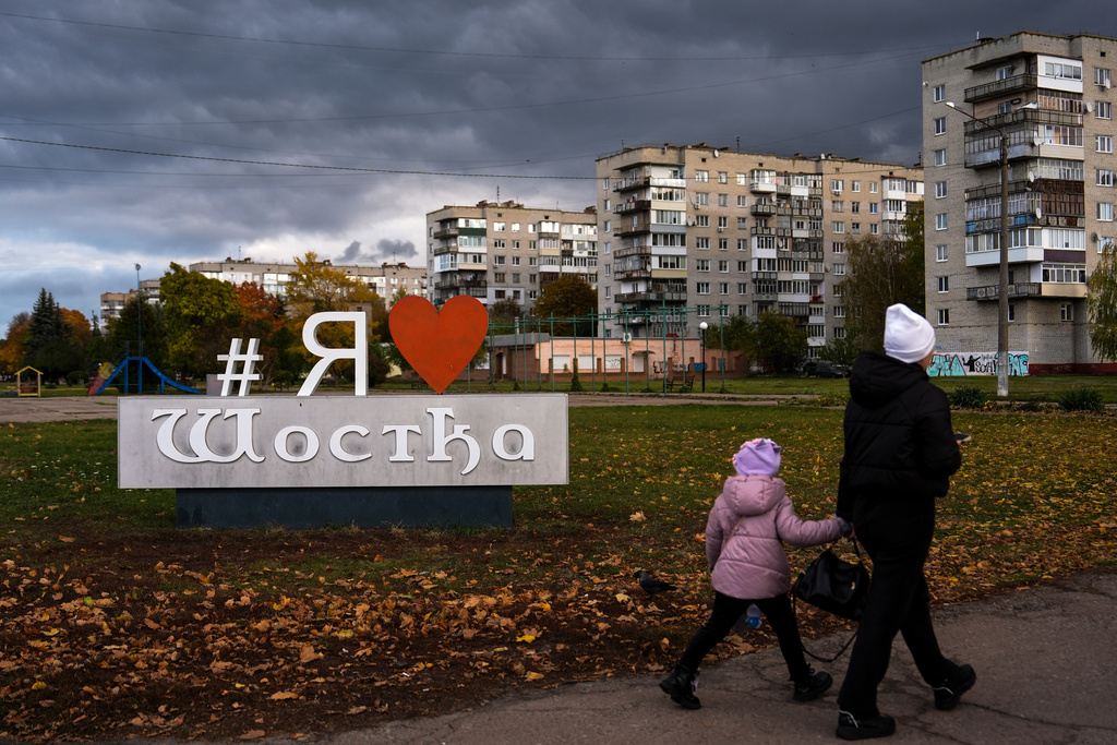 People walk through Shostka, Ukraine during a rolling blackout, Thursday, Oct. 16, 2025. (AP Photo/Julia Demaree Nikhinson)