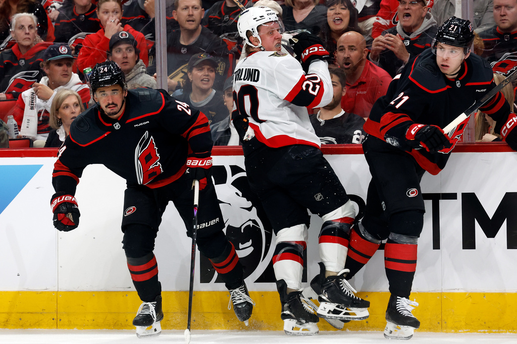 Ottawa Senators' Fabian Zetterlund (20) collides with Carolina Hurricanes' Seth Jarvis (24) and Alexander Nikishin (21) the first period of Game 2 of an NHL hockey Stanley Cup first-round playoff series in Raleigh, N.C., Monday, April 20, 2026. (AP Photo/Karl DeBlaker)